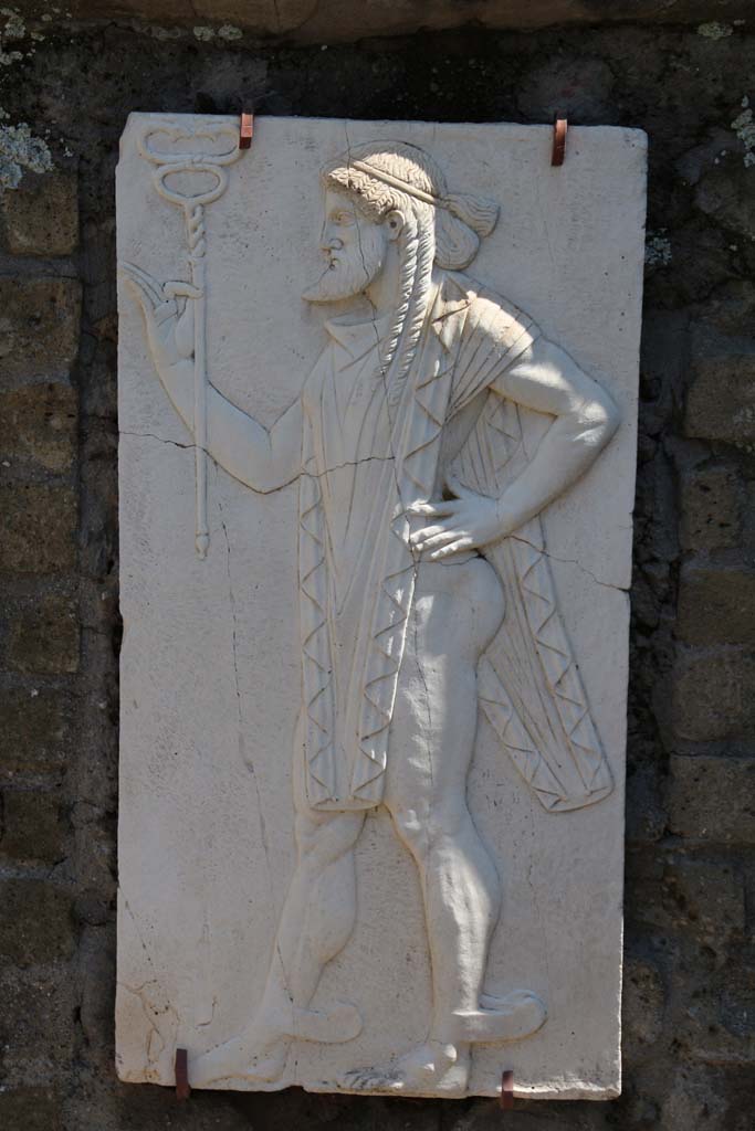 Herculaneum, April 2014. Sacred Area terrace, the shrine of Four Gods. Reproduction relief of Mercury. 
Photo courtesy of Klaus Heese.